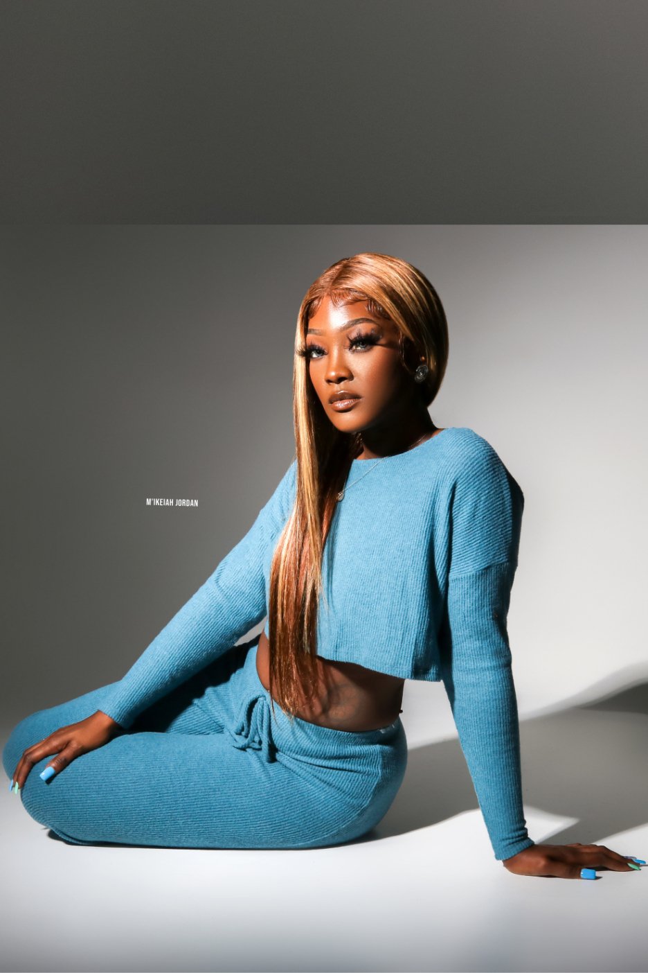 Woman wearing blue two piece crop top long sleeve pant set.